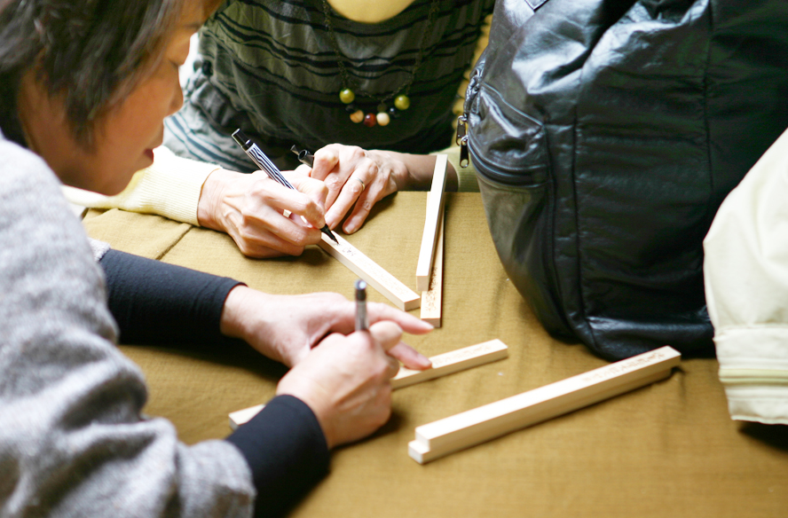 護摩木に祈願を書く人々