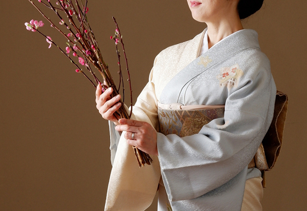 桃の花を抱く着物姿の女性